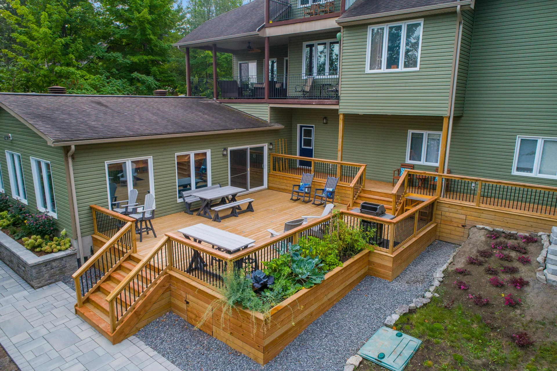 A beautiful, spacious wood and composite deck in a lush green backyard, ready for a summer gathering in Madison.