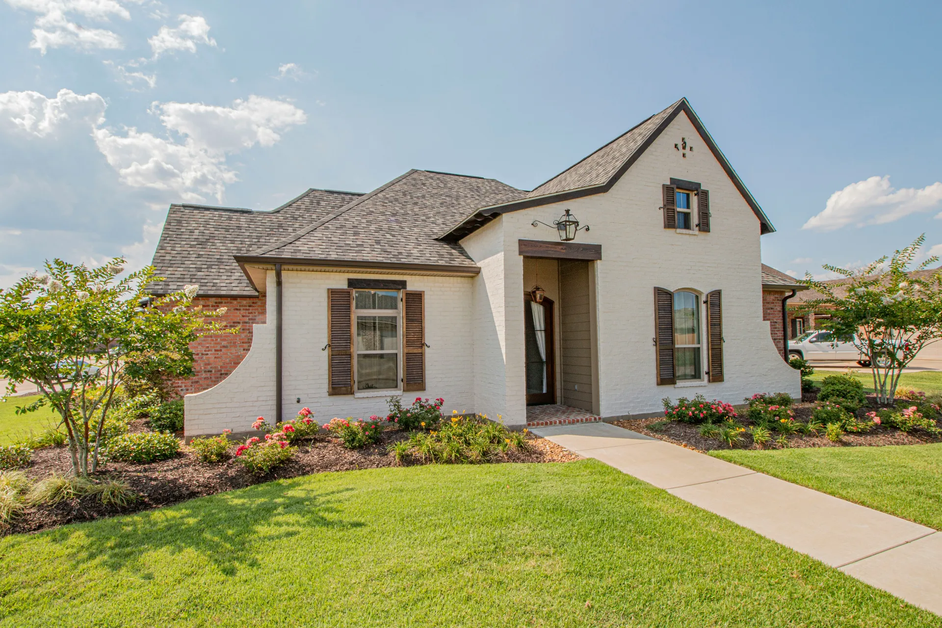 A well-maintained suburban house with clean, light gray vinyl siding.