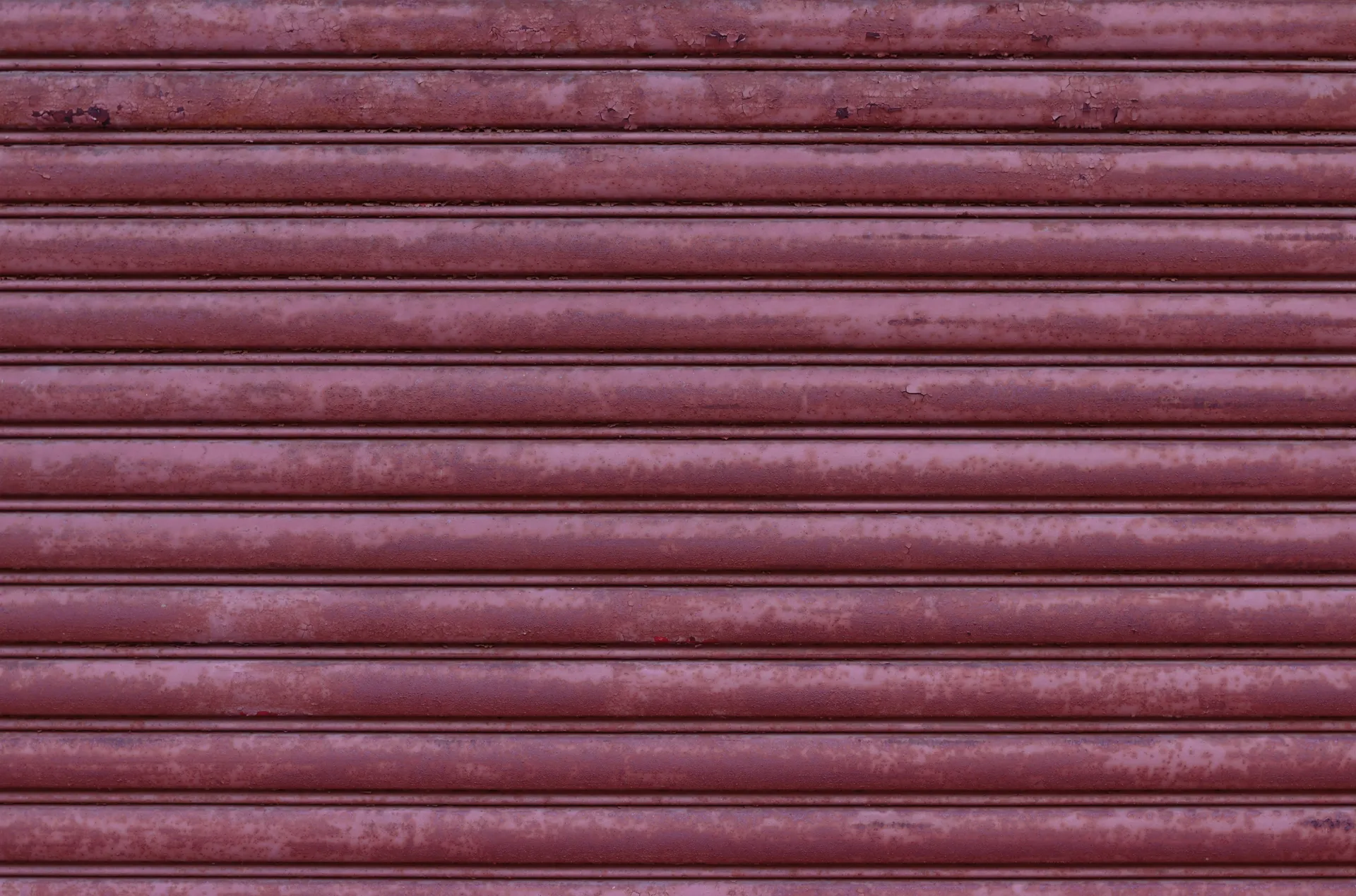 A close-up of a white garage door panel showing significant rust spots and peeling paint.
