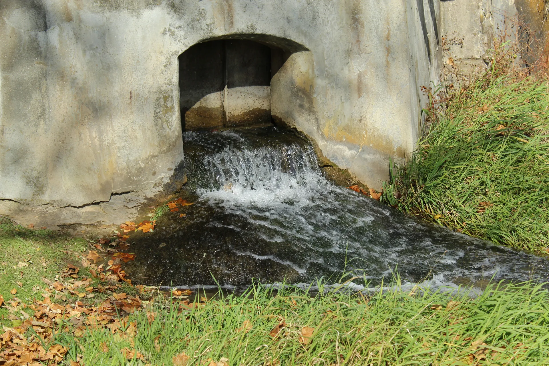A newly installed interior drainage channel along the base of a basement wall, leading to a sump pump.