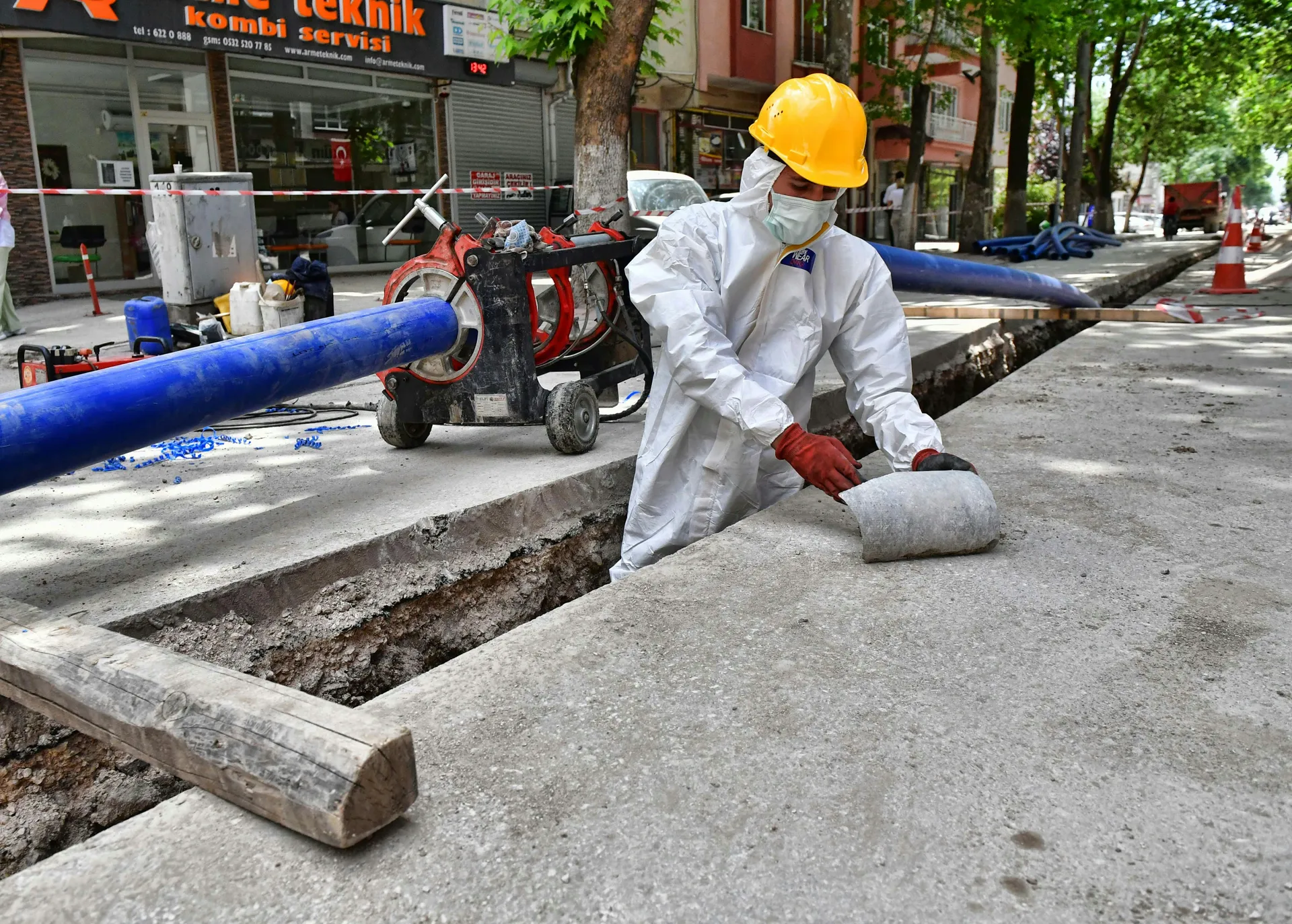A cross-section diagram showing a jackhammer breaking a concrete slab to expose a leaking pipe underneath.