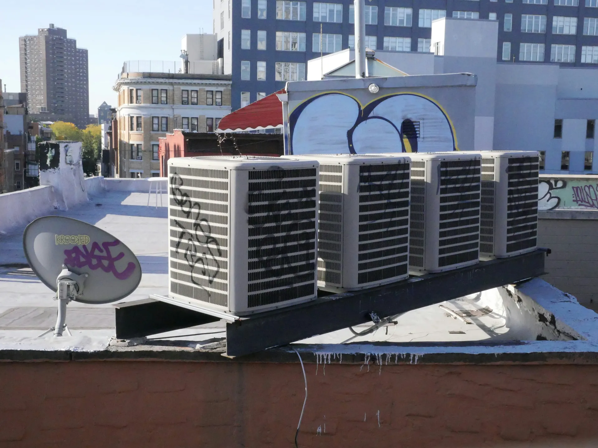 Multiple commercial HVAC rooftop units (RTUs) on the flat roof of a commercial building.