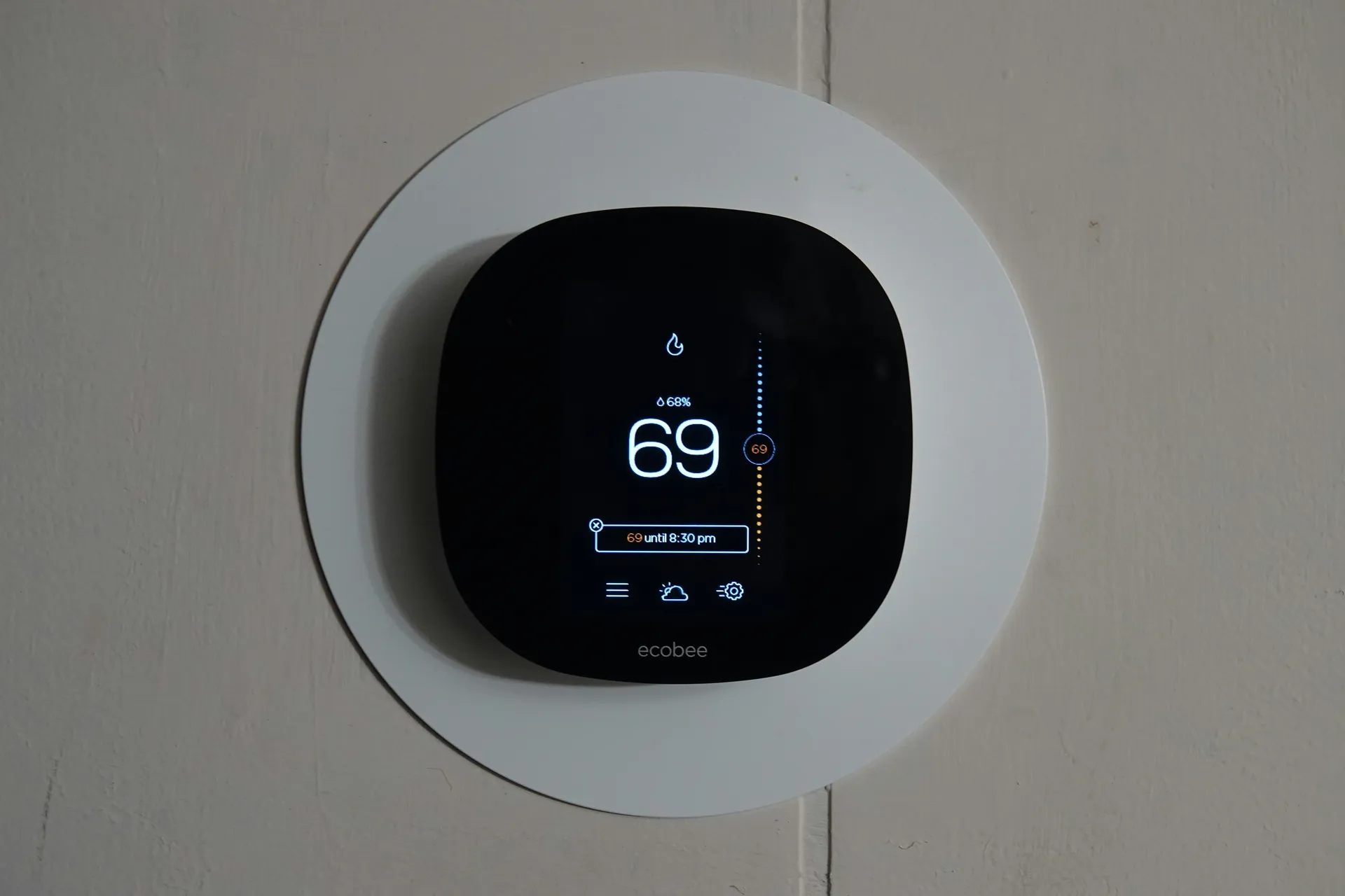 A modern smart thermostat on a wall displaying temperature settings, symbolizing home comfort control.