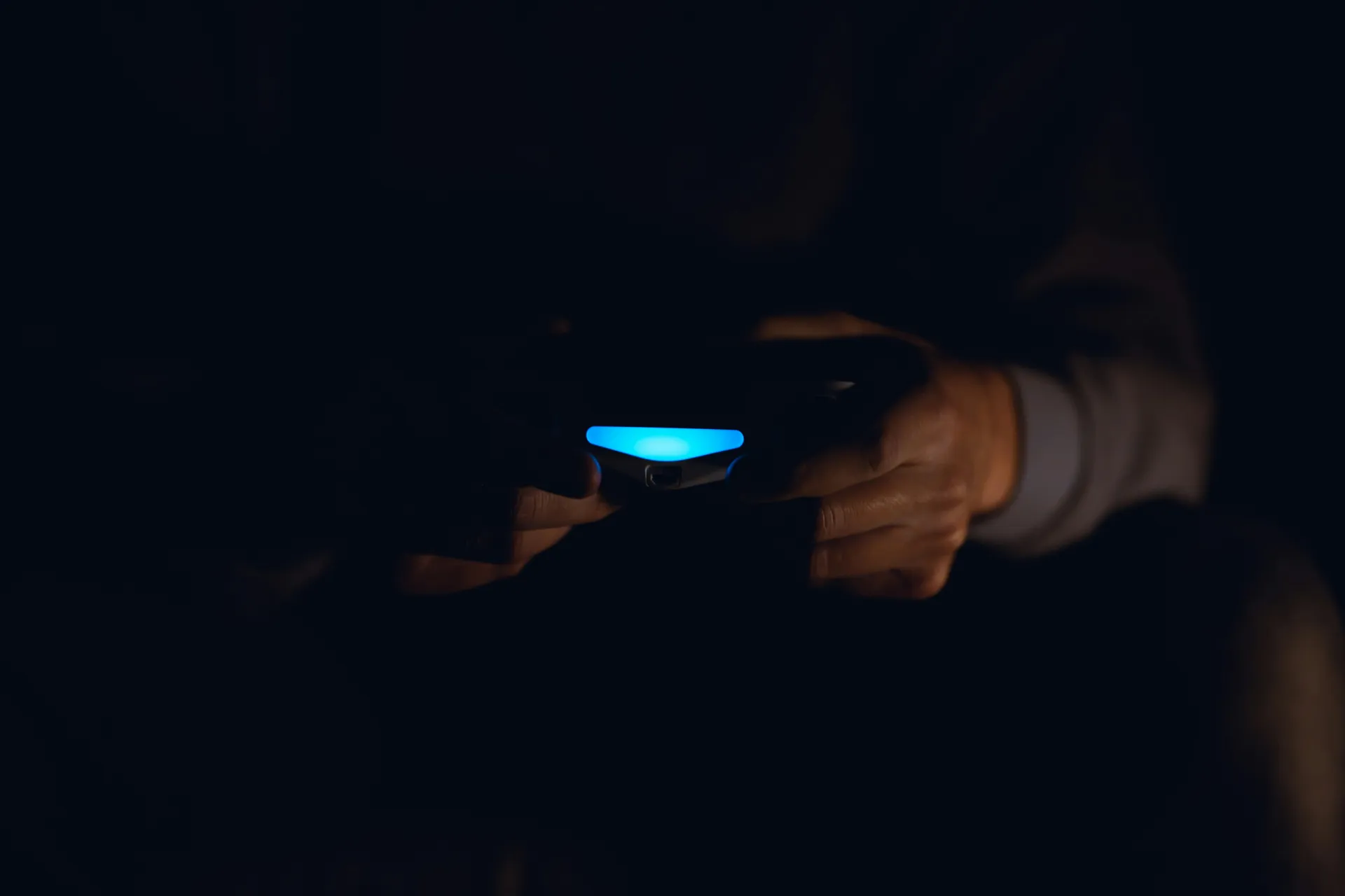 A homeowner looking at their furnace in a dark, cold basement, illuminated by a flashlight.