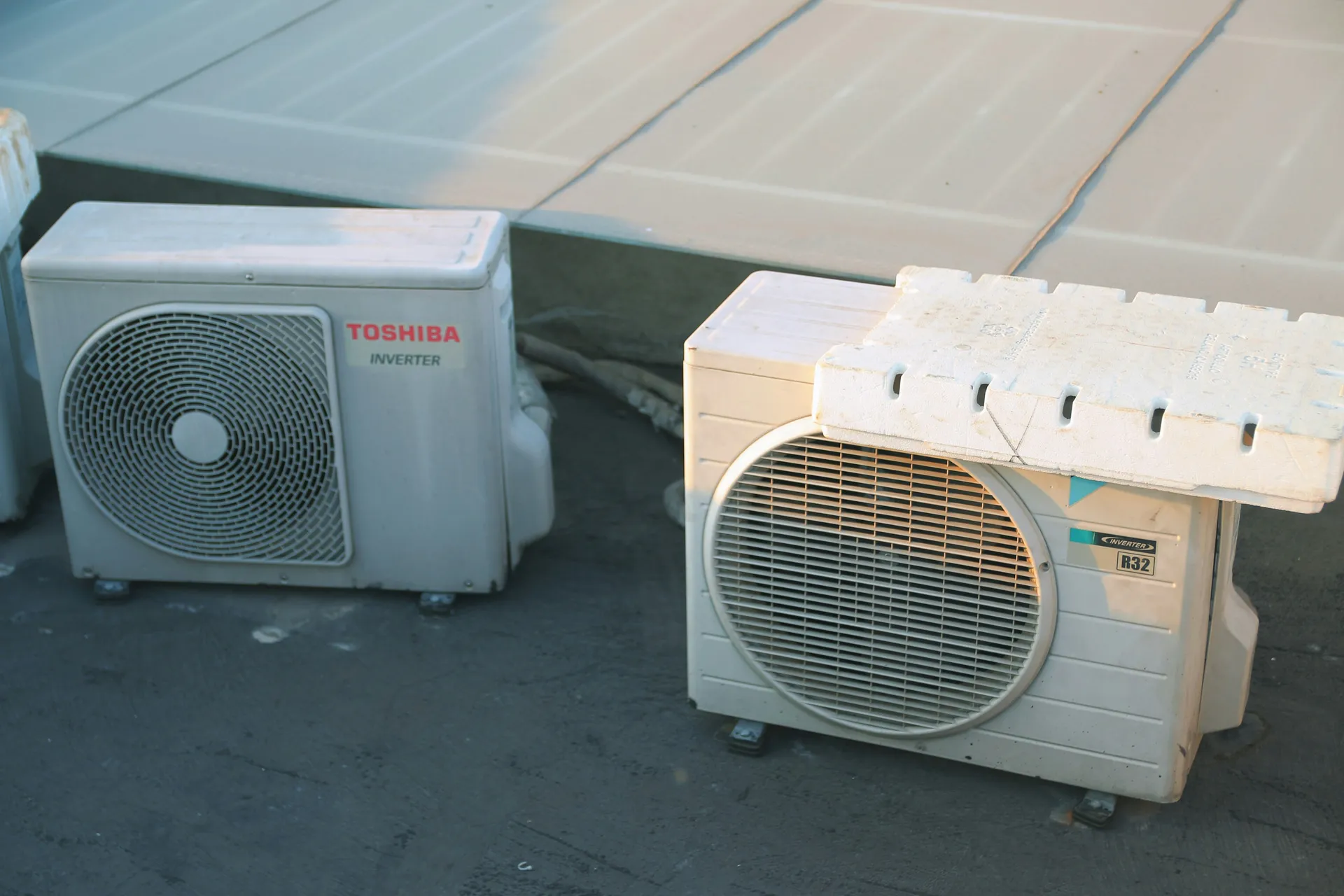 A modern heat pump's outdoor unit next to a clean residential house, ready for troubleshooting.